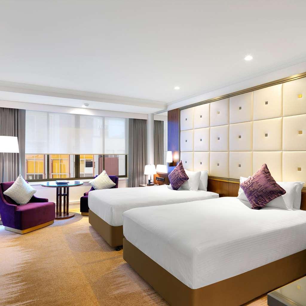 Amora Hotel Jamison Sydney Szoba fotó The photo depicts a modern hotel room featuring two beds with white linens. The beds are positioned against a wall that has a stylish design with light-colored panels. There are two decorative pillows on each bed. To the side, there is a purple accen