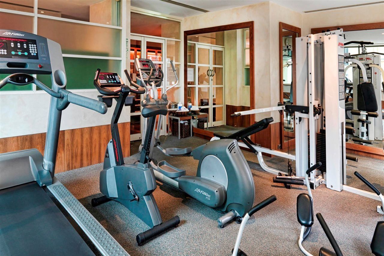 Amora Hotel Jamison Sydney Kültér fotó The photo shows an indoor gym space equipped with various fitness machines. There is a treadmill, an elliptical machine, and a multi-station weight machine. The gym has a clean and modern design, with wooden accents and large windows that allow natur